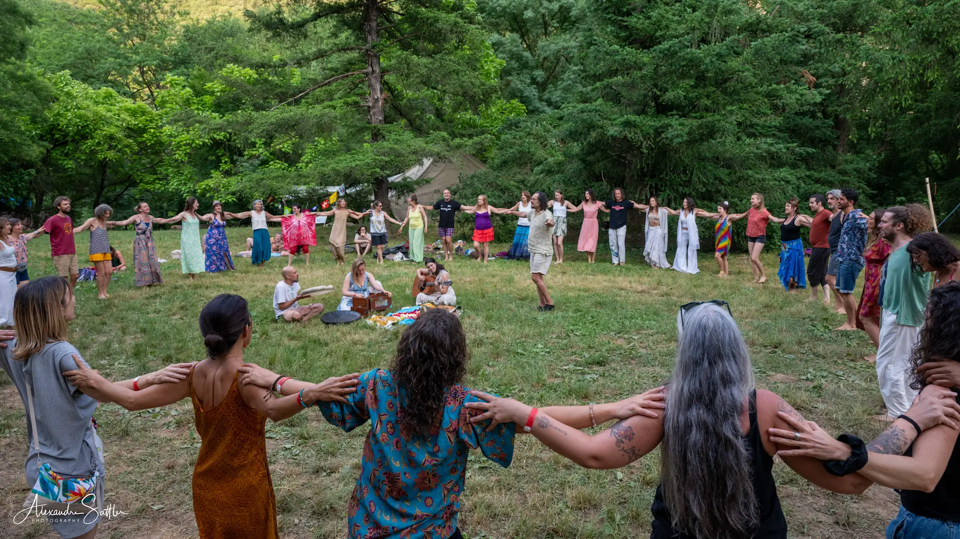 Cercle de danse au Festival Mantra Joie, participants enlacés dos à dos